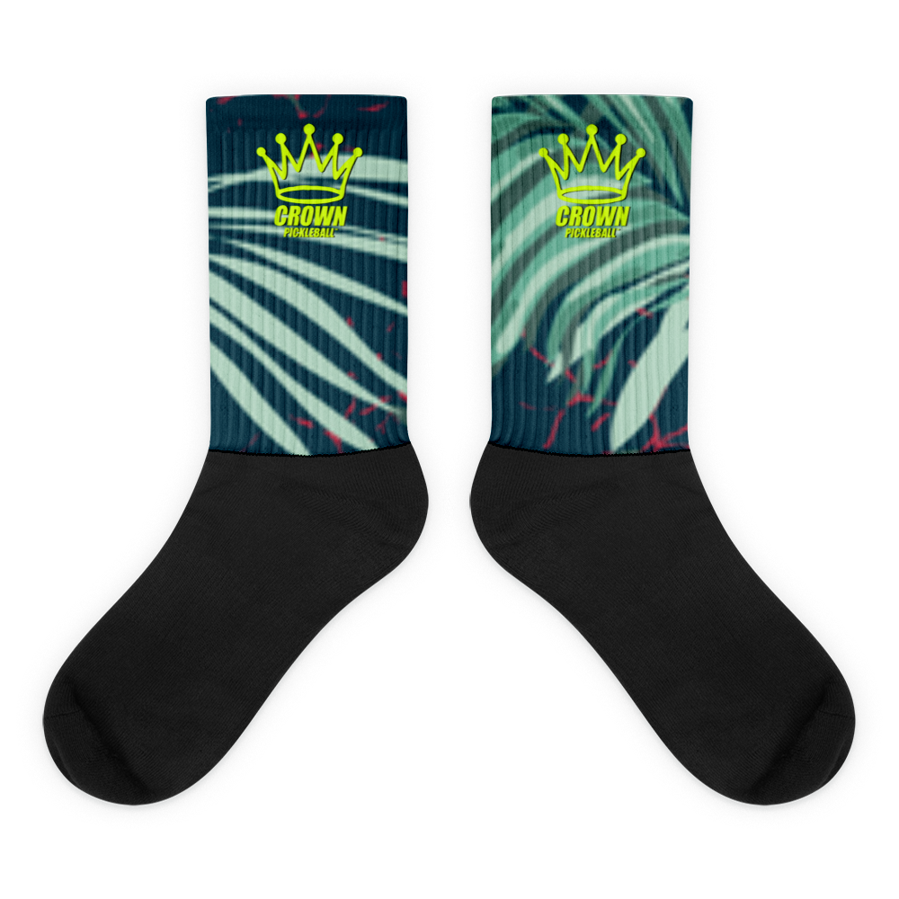 A pair of black socks with a teal and green palm leaf design and a yellow "Crown Pickleball" logo.