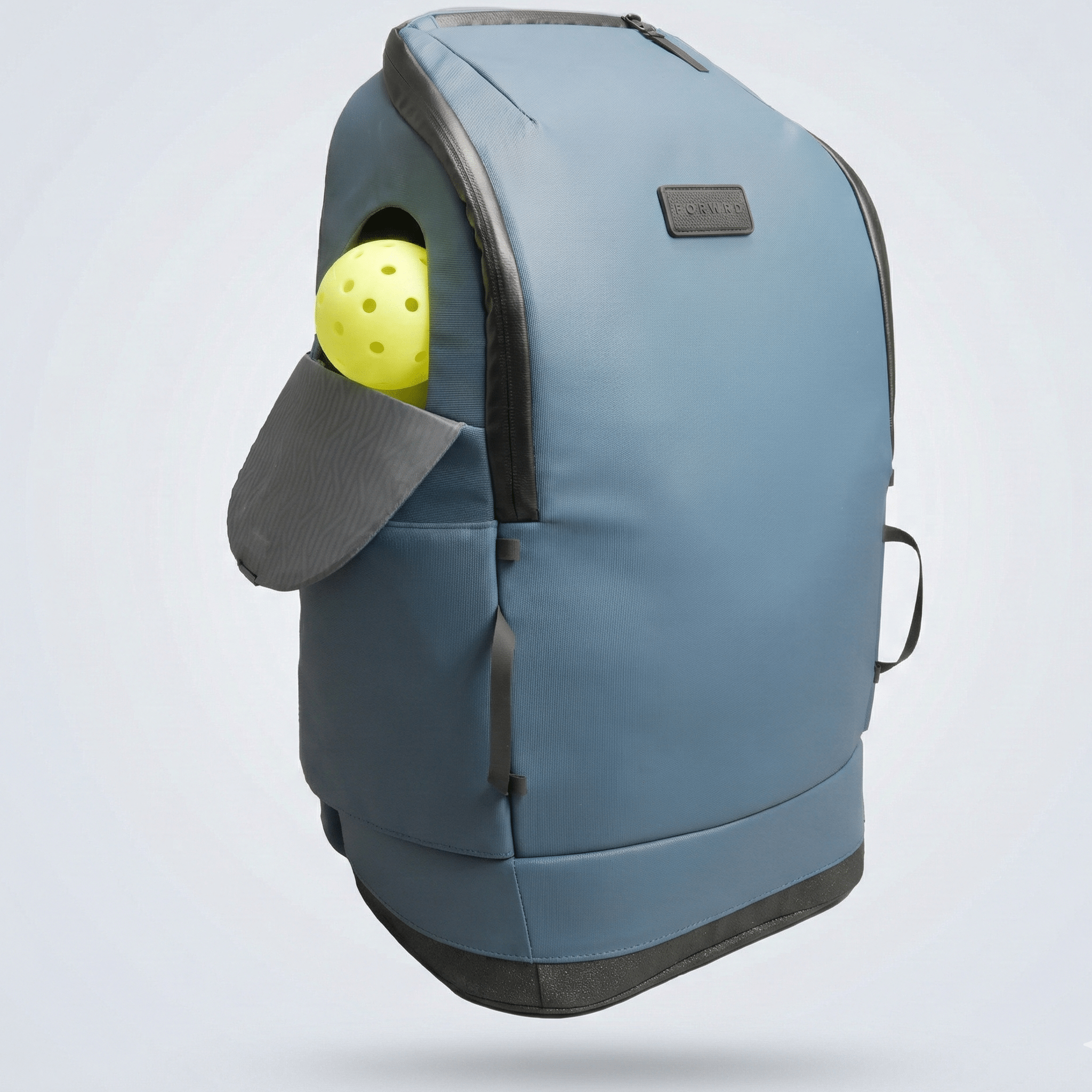 Blue pickleball backpack by FORWRD with a yellow pickleball visible in an open side pocket, floating against a light background.