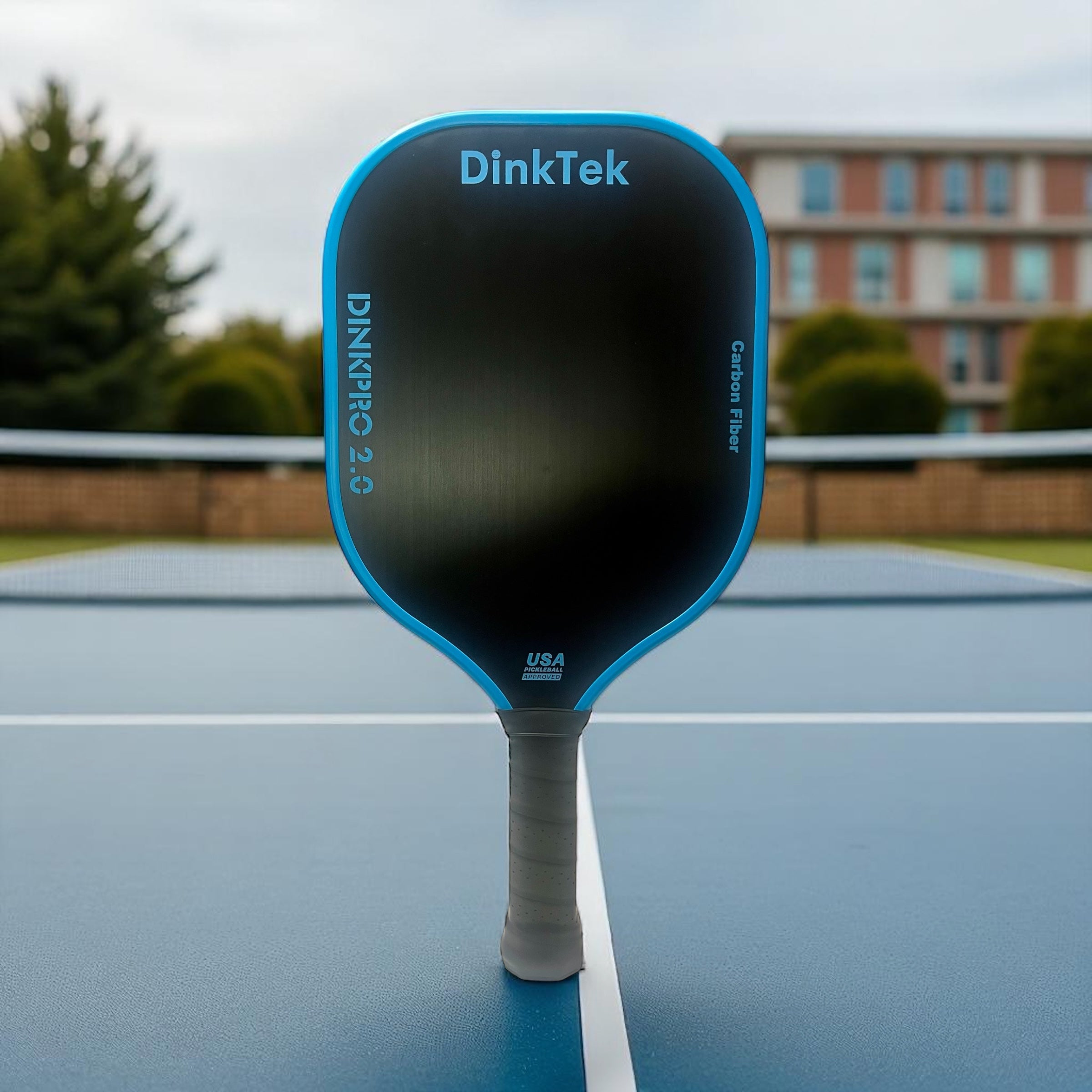Blue and black pickleball paddle on a blue court.
