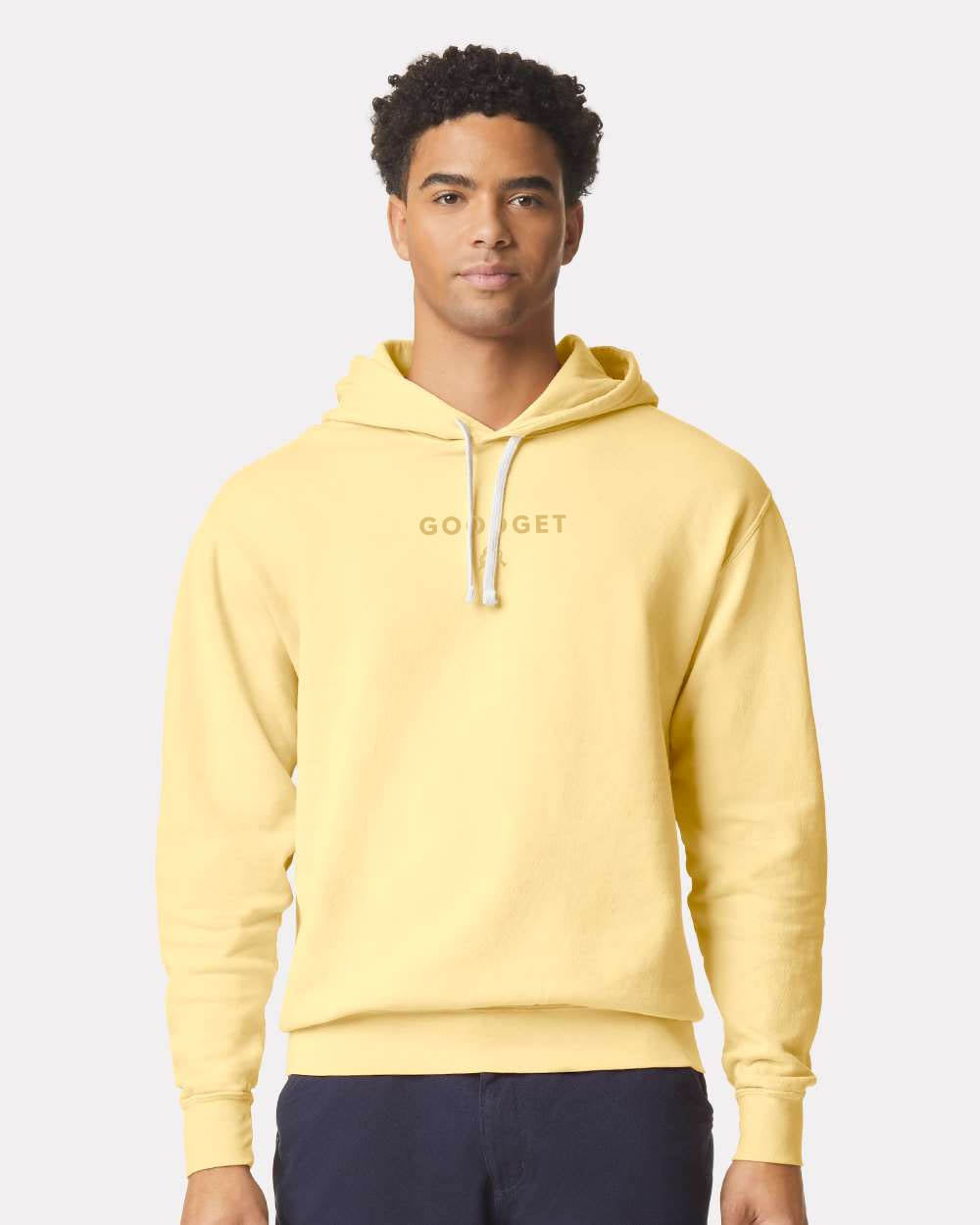 Light yellow Everyday Hoodie with 'GO GET' text by Good Get, worn by a man with white drawstrings.
