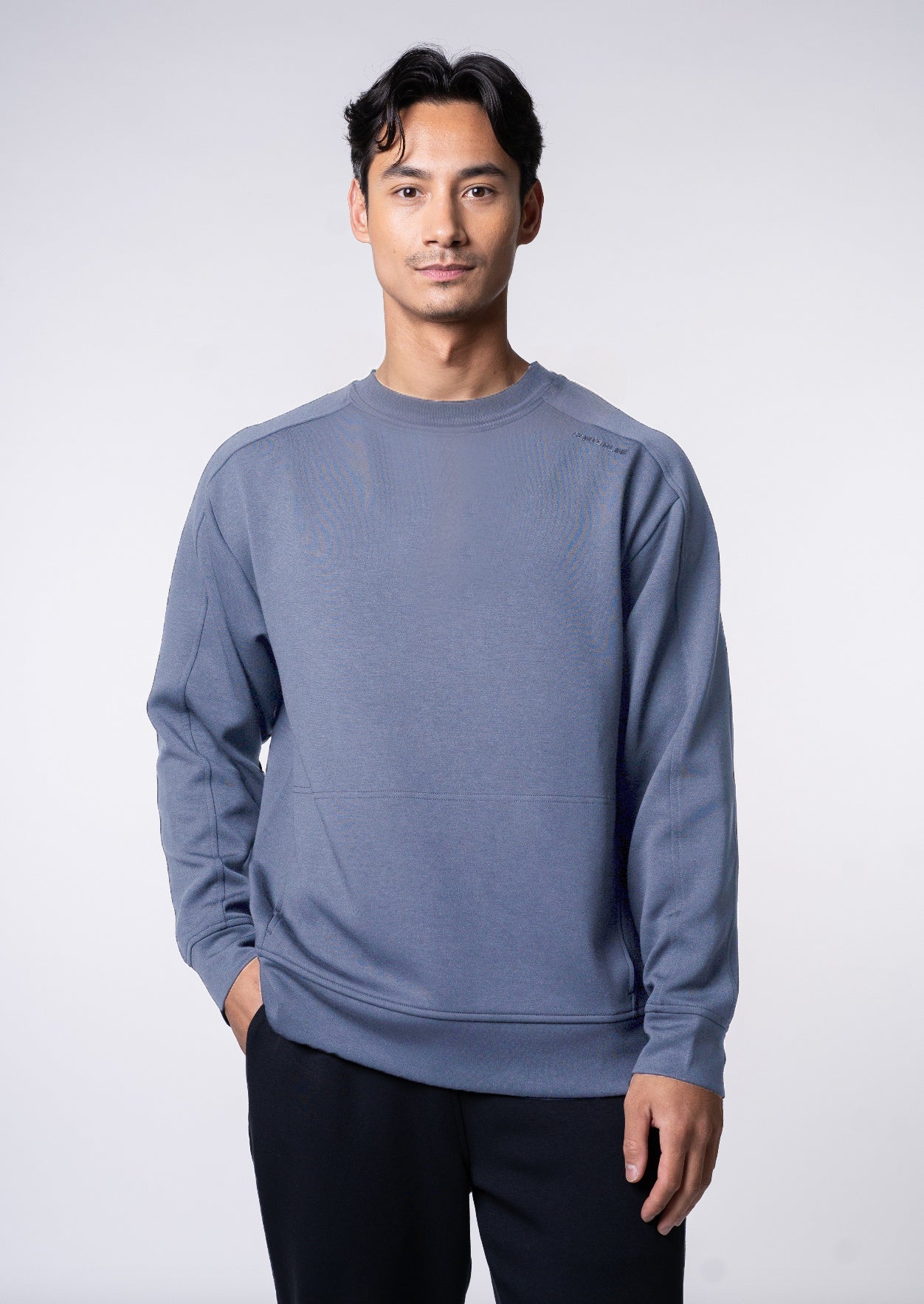 Man in a blue sweatshirt and black pants.