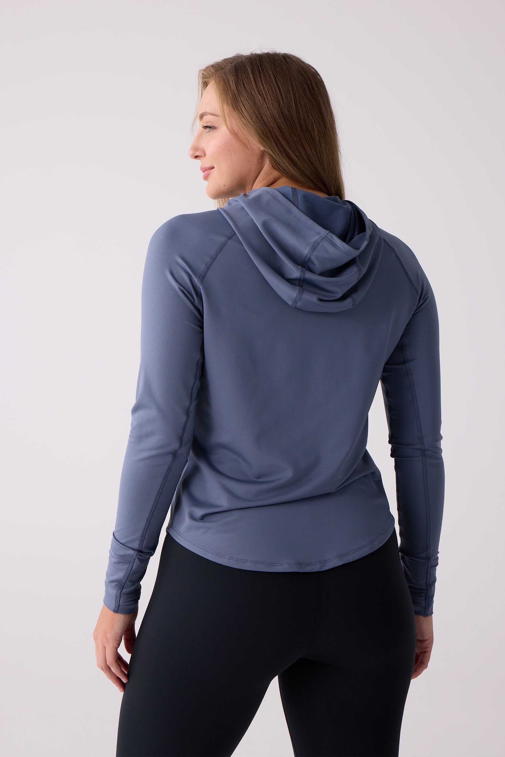 Slate blue Women's Layering Hoodie by Centerline Athletics, seen from the back on a woman wearing black leggings.