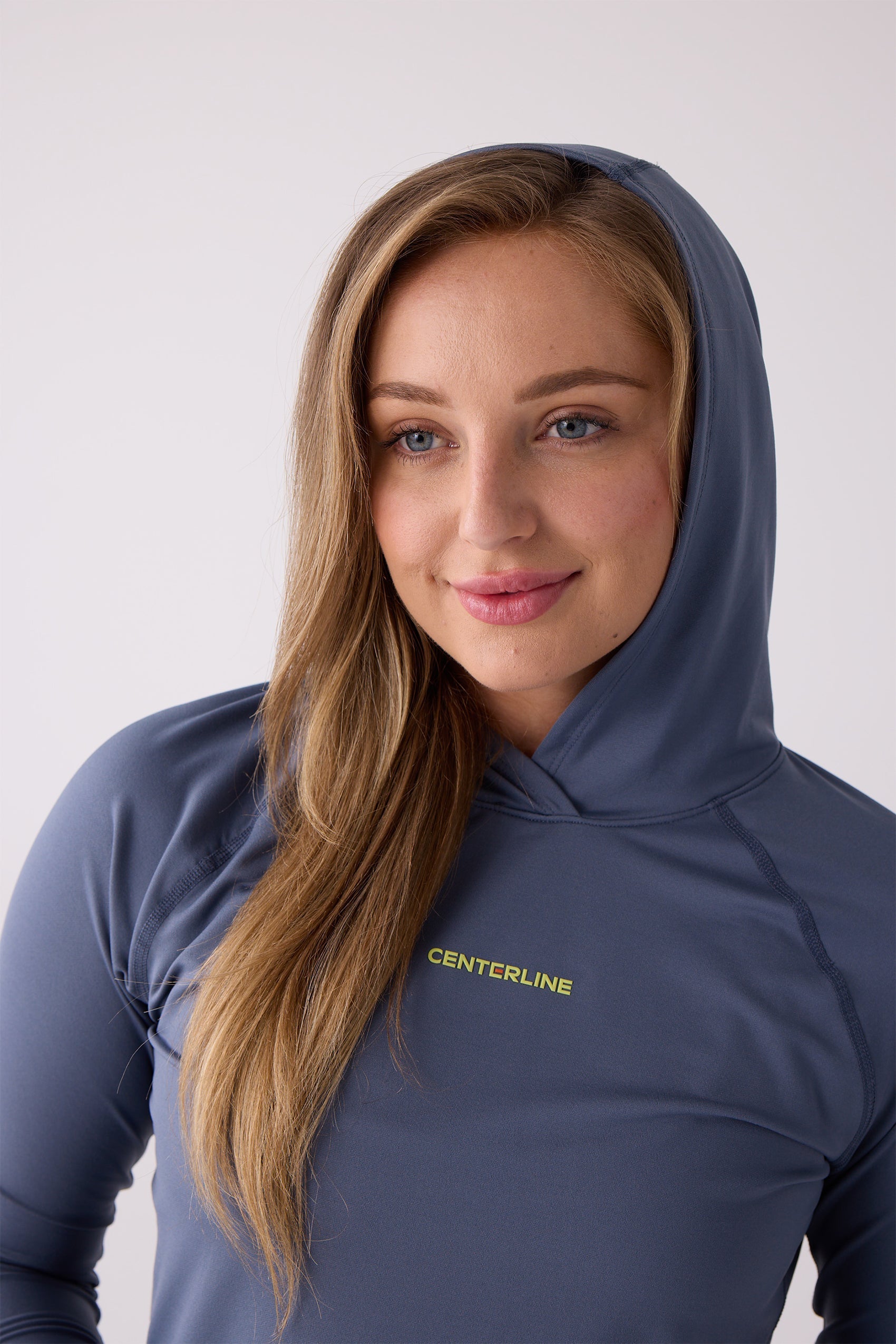 Slate blue women's layering hoodie from Centerline Athletics, featuring a yellow 'CENTERLINE' logo and raglan sleeves.