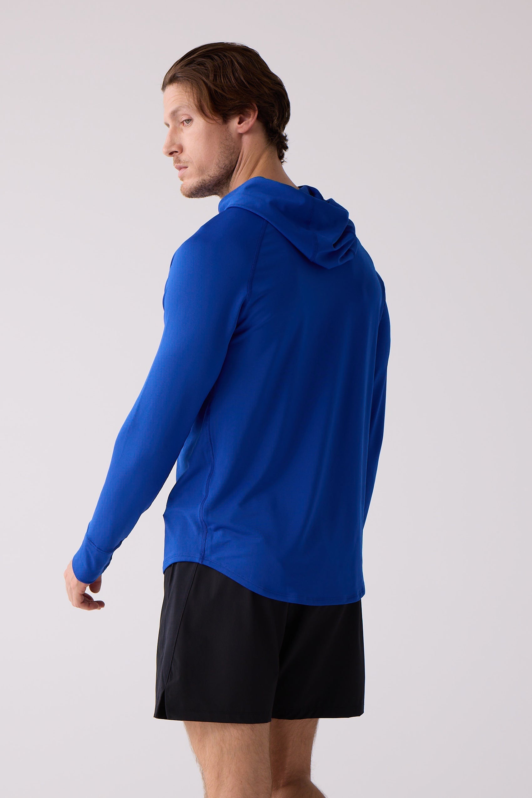 Blue long-sleeve men's layering hoodie by Centerline Athletics, worn by a man in black shorts, shown from the back and side.