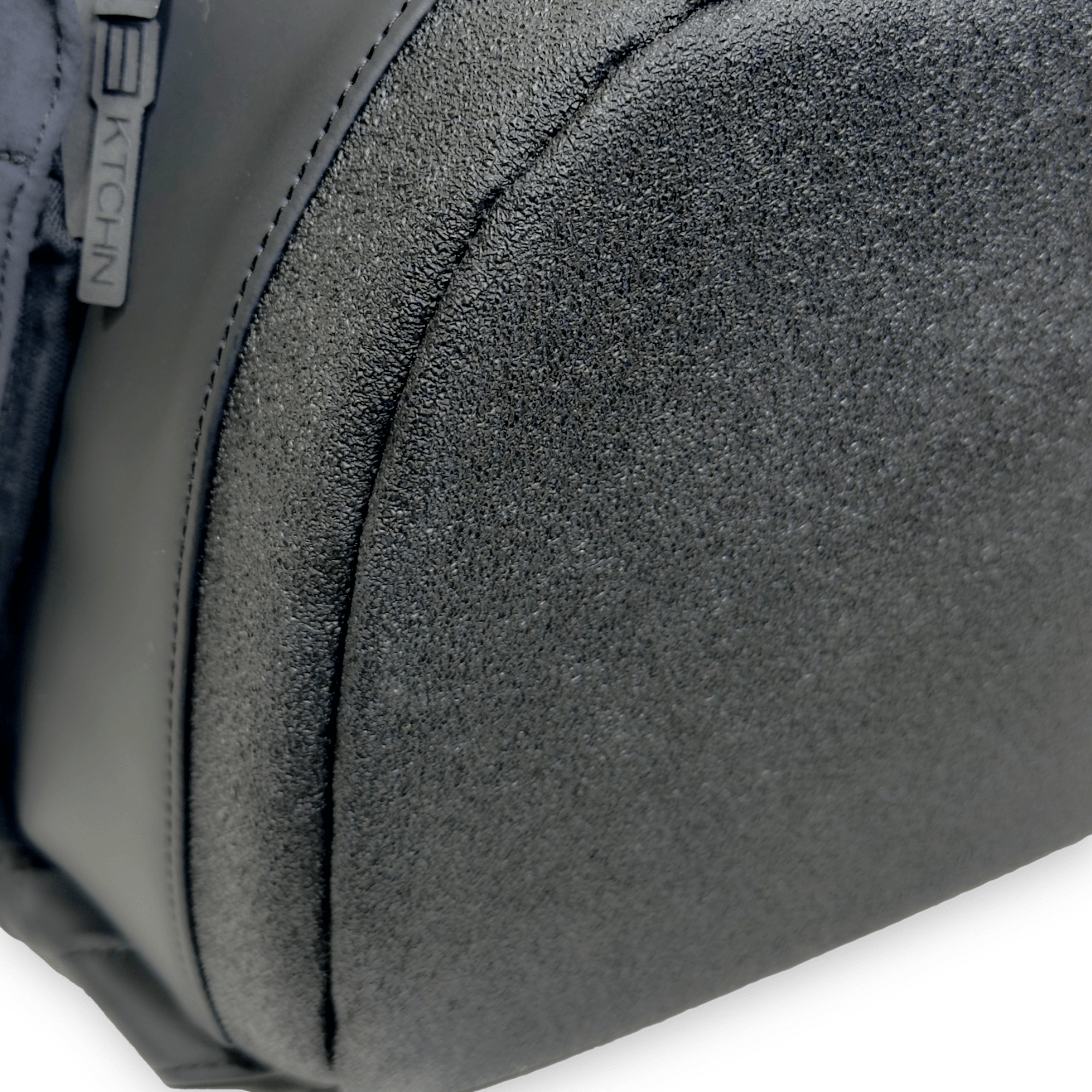 Black pickleball bag by FORWRD, side view showing pebbled and smooth textured materials, with 'KTCHN' zipper pull.